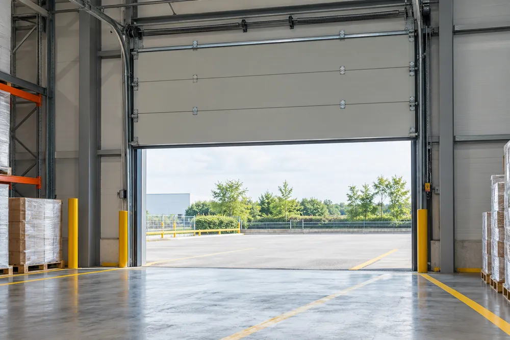Sectional overhead door and tracks inside an industrial warehouse